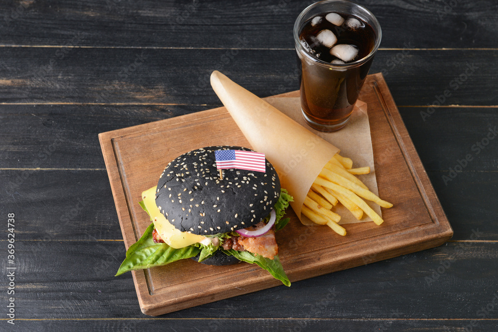 Tasty burger with black bun, french fries and cola drink on table - obrazy, fototapety, plakaty 