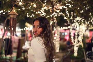 Poster - Beautiful shot of a young caucasian female with Christmas lights background