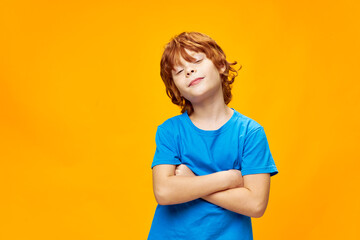 red-haired boy crossed arms and blue t-shirt 