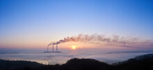 Panoramic View Of Three Smoking Stacks Of Thermal Power Station On The Horizon Taken From The Hill, Pipes Are In Evening Fog On Blue Sky, Copy Space. Concept Of Ecology And Environmental Pollution.