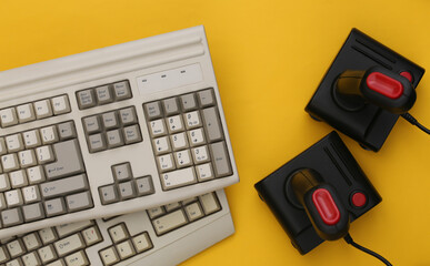 Wall Mural - Old keyboard and joysticks on yellow background. Retro gaming. 80s. Top view. Flat lay