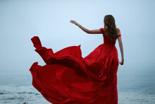 Woman In A Long Red Dress. Back View