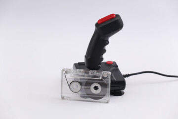 Wall Mural - Retro joystick with audio cassette on a white background. Attributes 80s