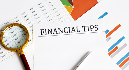 Poster - FINANCIAL TIPS is written on a white sheet on charts. Financial concept