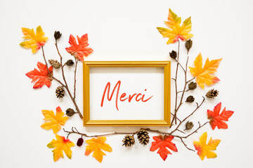 Wall Mural - golden frame with french text merci means thank you. beautiful, colorful autumn leaf decoration with