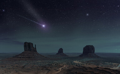 shooting star shining in night sky above monument valley, utah