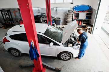 Car repair and maintenance theme. Mechanic in uniform working in auto service.