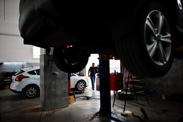 Car repair and maintenance theme. Mechanic in uniform working in auto service.