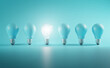 © natanaelginting - Outstanding Idea Concept. Glowing Bulb Between Unlit Blue Bulbs Minimal.