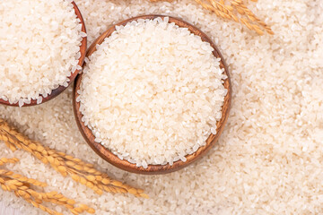 Wall Mural - Raw rice in a bowl and full frame in the white background table, top view overhead shot, close up