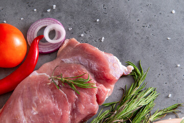 Wall Mural - raw meat, pork tenderloin with spices, rosemary, onion,  chili  pepper, tomato on a gray  top view