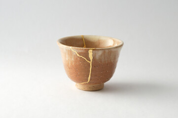 Wall Mural - Japanese kintsugi ceramic sake cup, restored with real gold. Antique pottery kintsukuroi.
