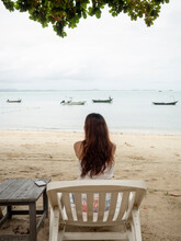 Asian Woman Sitting On Beach Chair Looking Away To Sea View. Samed, Thailand.