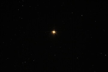 Wall Mural - a bright golden star shining in the night sky