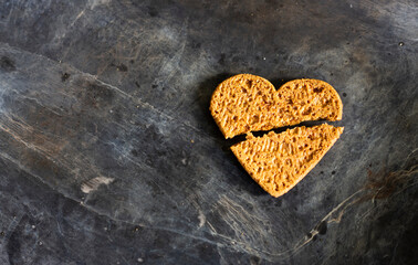 Broken heart cookies on dirty black background. 