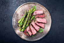 Barbecue Dry Aged Wagyu Roast Beef Steak With Green Asparagus And Lettuce Offered As Top View On A Rustic Modern Design Plate