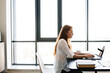 © Drobot Dean - Image of serious redhead businesswoman working with laptop while sitting