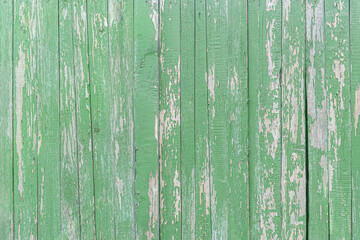 abstract background of an old painted green wooden fence close up