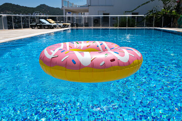 Poster - pink inflatable donut doughnut floating mattress in swimming pool. Beach pool accessories. Summer holiday concept