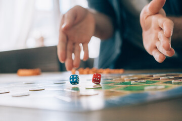 Board game and hands roll dice close-up.