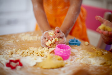 Child's hands holding the dough for modeling on a cutting Board with colorful cookie cutters