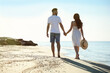 © New Africa - Happy young couple walking on beach near sea. Honeymoon trip