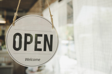 Open. coffee cafe shop text on vintage sign board hanging on glass door in modern cafe coffee shop, reopening cafe restaurant, retail store, small business owner, takeaway food, food and drink concept