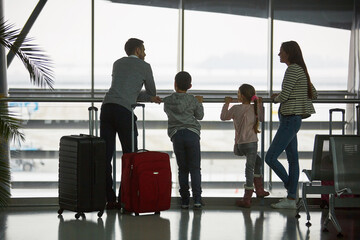 Wall Mural - Family is waiting in the airport terminal for the connecting flight