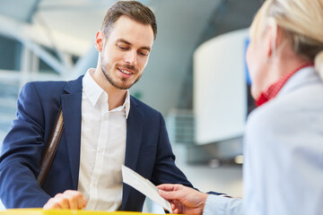 Wall Mural - Service agent at check-in controls air ticket