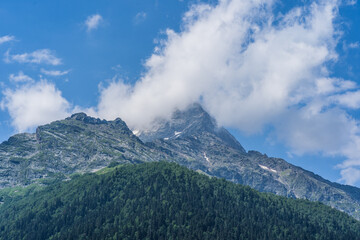 Peaks of magnificent rocks located against bright cloudy sky on sunny day in nature