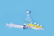 © maribel.nn - many multicolored pills, syringe and medicine bottle on blue background