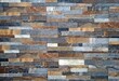 Wall cladding for interiors made of natural stones strips with different sizes. Colors are gray,brown and white. Background and texture