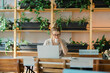 © Javier Pardina/Stocksy - Woman spending time in a cafeteria with phone, coffee and books.
