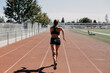 © Leah Flores/Stocksy - Back of Woman Running on Track