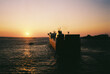 © Nina Zivkovic/Stocksy - A ferry leaving the port in the sunset.