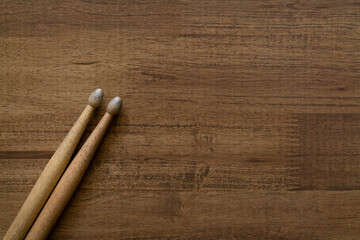 Drum stick on wooden table background, top view, music concept