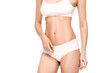 © LIGHTFIELD STUDIOS - cropped view of young woman with perfect body in panties and top standing isolated on white
