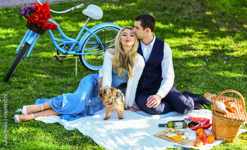 This is love. happy couple in love. woman and man lying in park and enjoying day together. valentines day picnic. romantic picnic in park with dog. cute couple on date on blanket. vintage bike