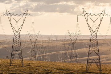 High voltage post. High-voltage transmission lines at sunset.