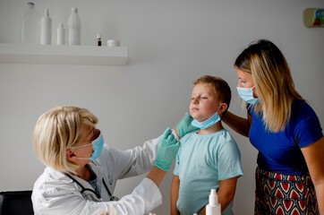 Doctor taking a sample from a boy's nose using a cotton swab