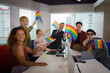 © Mongkolchon - diverse business people with LGBTQ have rainbow flag on hand