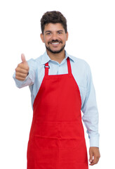 Wall Mural - Handsome hispanic waiter showing thumb up