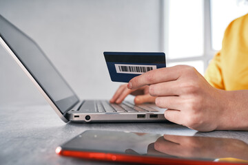 Close up shot of bank card in hand of woman. Shopping online from home