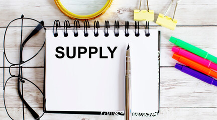 Poster - SUPPLY written in a notebook on white background with office tools