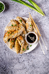 Fried dumplings gyoza with soy sauce, and chopsticks.