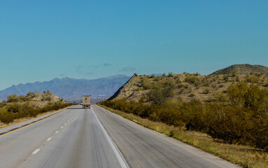 Wall Mural - Big freight truck with flatbed going down the winding mountain road