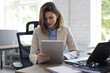 © ty - Attractive smiling woman working on a tablet in modern office.