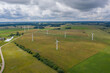 Aerial view of white wind turbines in green fields in summer