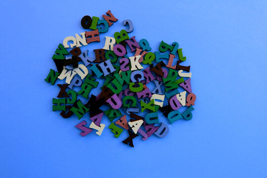 The letters of the alphabet are scattered randomly on a blue background.