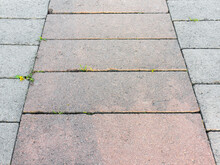 Decorative Colorful Sidewalk Pavement. Tiled Floor With Grey Tiles Crossed By A Diagonal Double Stripe Of Red Tiles Viewed At A Low Angle, Full Frame Background Pattern